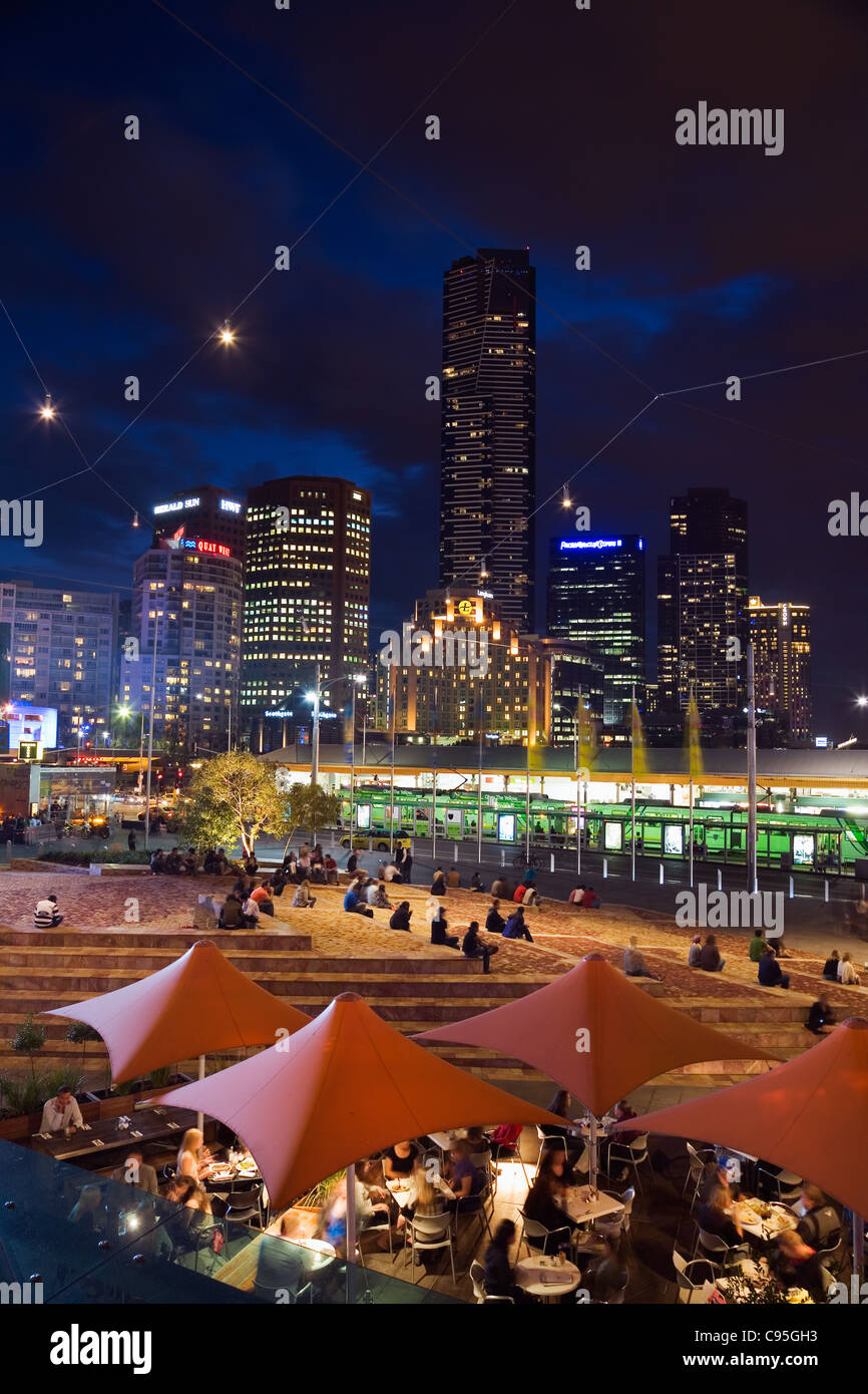 Cafe am Federation Square mit Nacht Skyline im Hintergrund.  Melbourne, Victoria, Australien Stockfoto