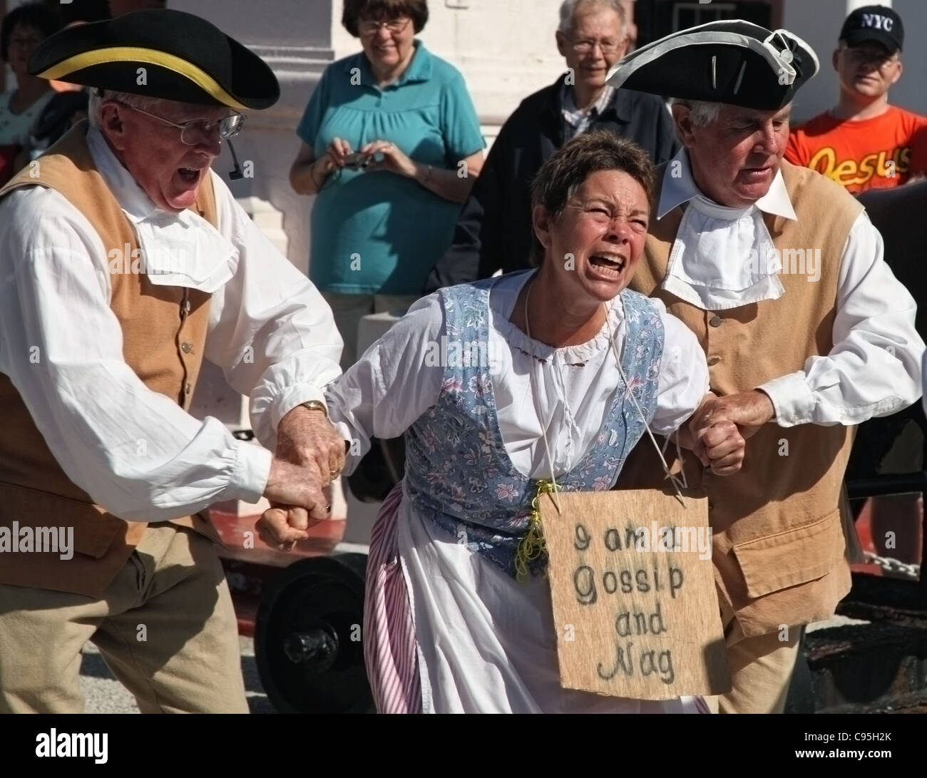 Eine Frau wird zu 'The Dunking Stuhl", als"Nag und Klatsch"in ein historisches Reenactment in St. Georges, Bermuda verurteilt. Stockfoto