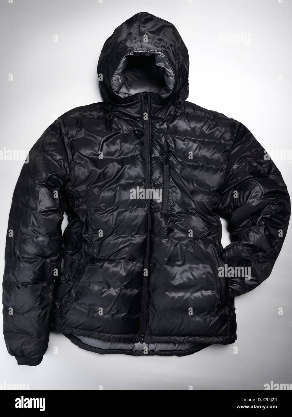 Schwarze Winterjacke mit Kapuze. Isoliert auf grauem Hintergrund. Stockfoto