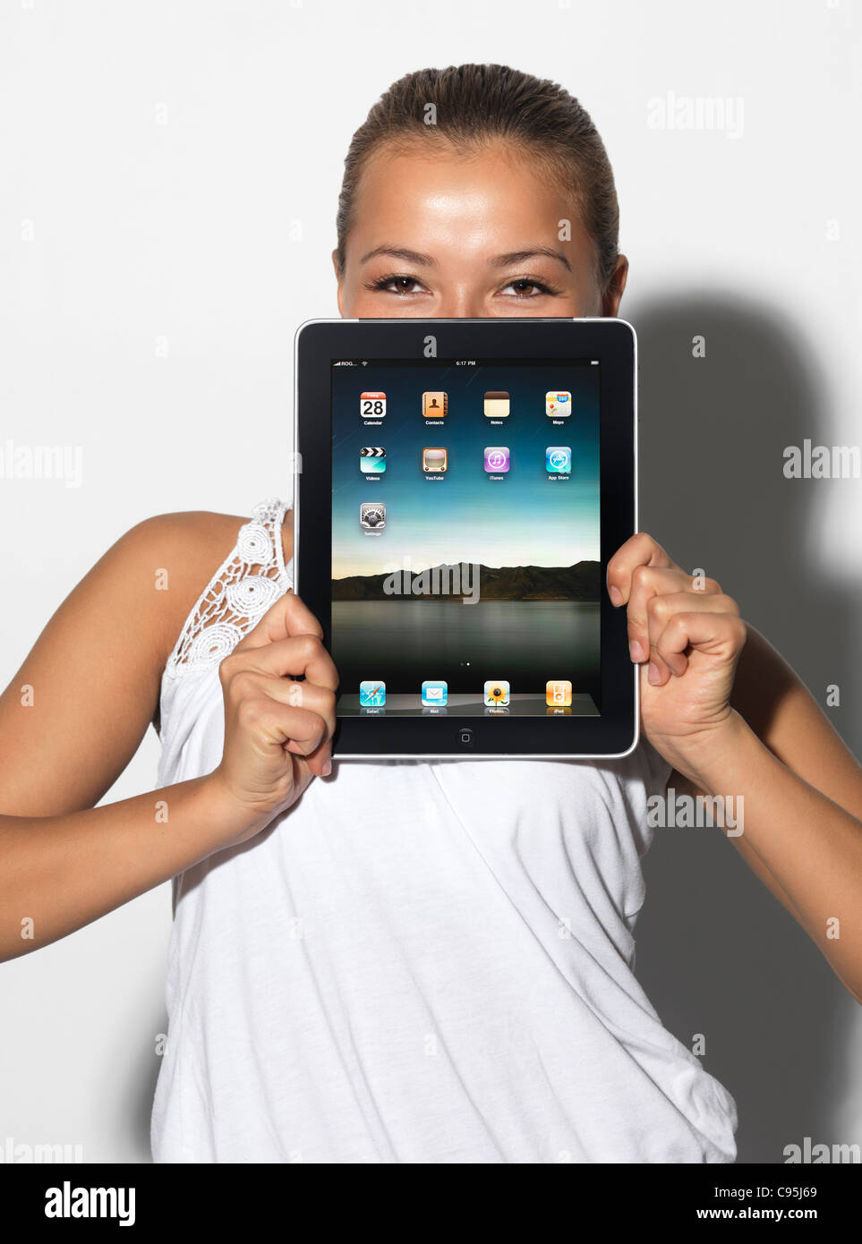 Lizenz erhältlich unter MaximImages.com - lächelnde junge asiatische Studentin mit Apple iPad Tablet in der Hand Stockfoto