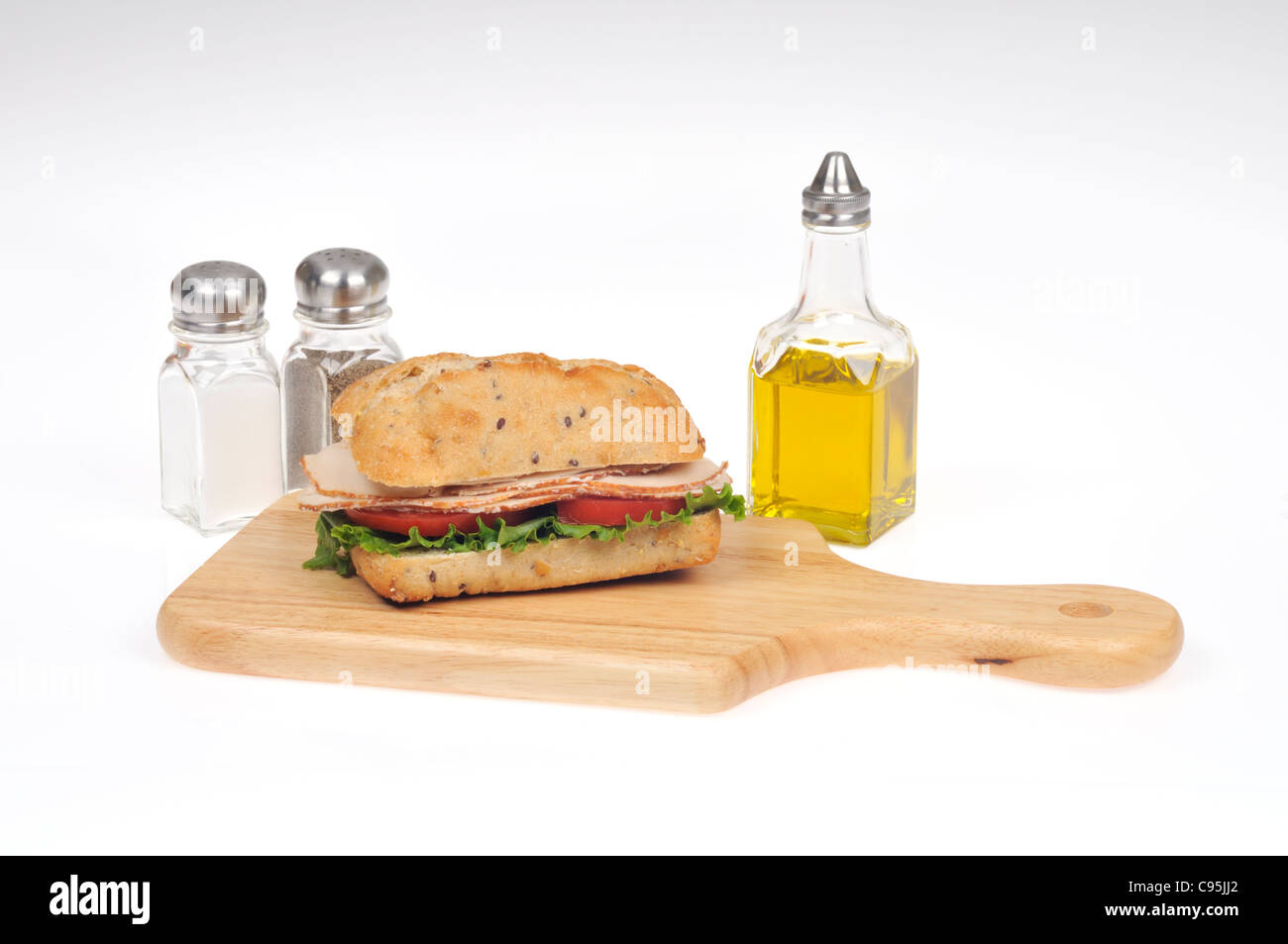 Chicken submarine Sandwich mit Salat und Tomate ciabatta Roll auf Holz deli Board mit Würzen mit Salz, Pfeffer und Öl. Stockfoto
