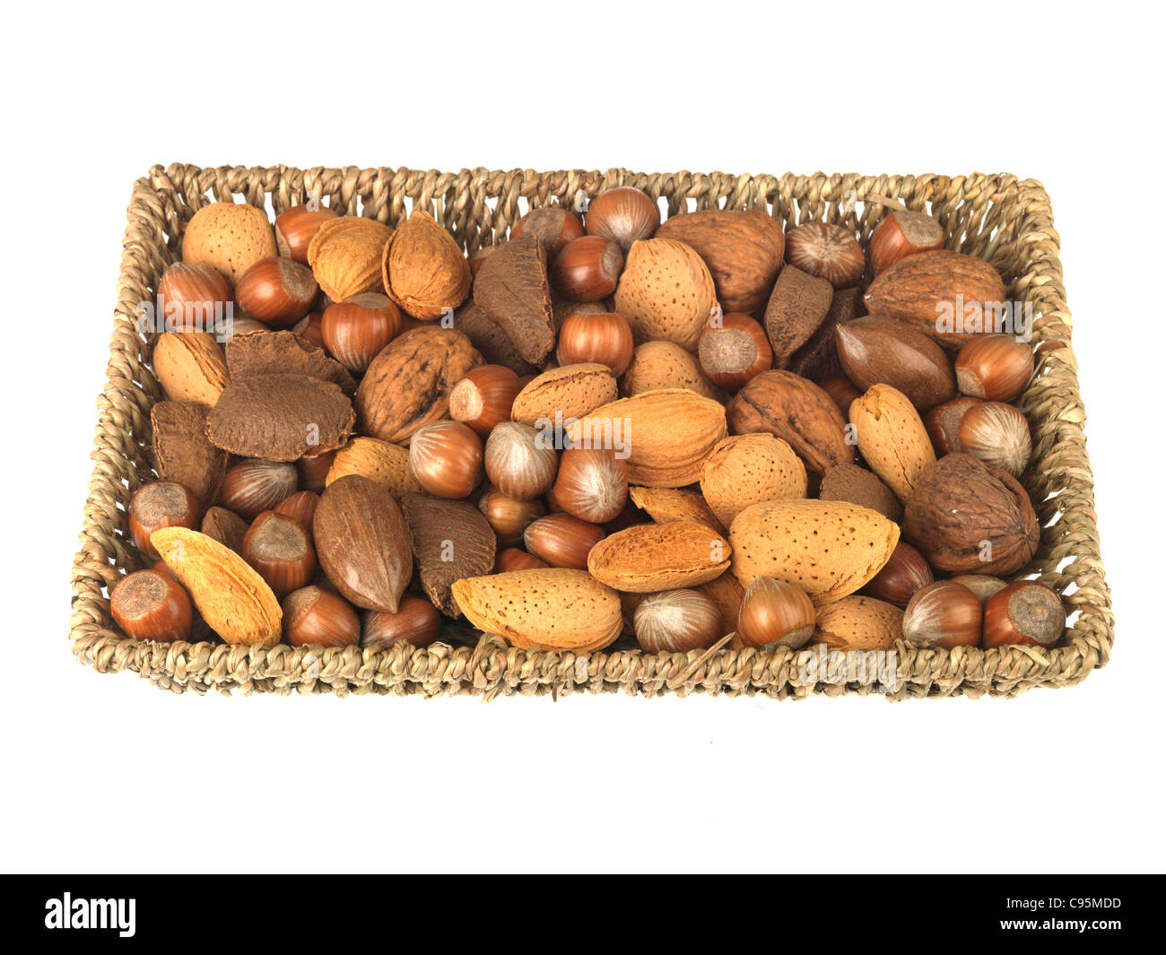 Weidenkorb oder Fach Der gesamte Allgemeine gesunde Nüsse mit ihren Lagerschalen auf gegen einen weißen Hintergrund mit Freistellungspfaden und keine Leute Stockfoto