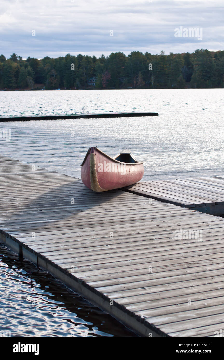 Eine rote Kanu wird auf einem Steg am See in Muskoka, Ontario, Kanada gezogen. Stockfoto