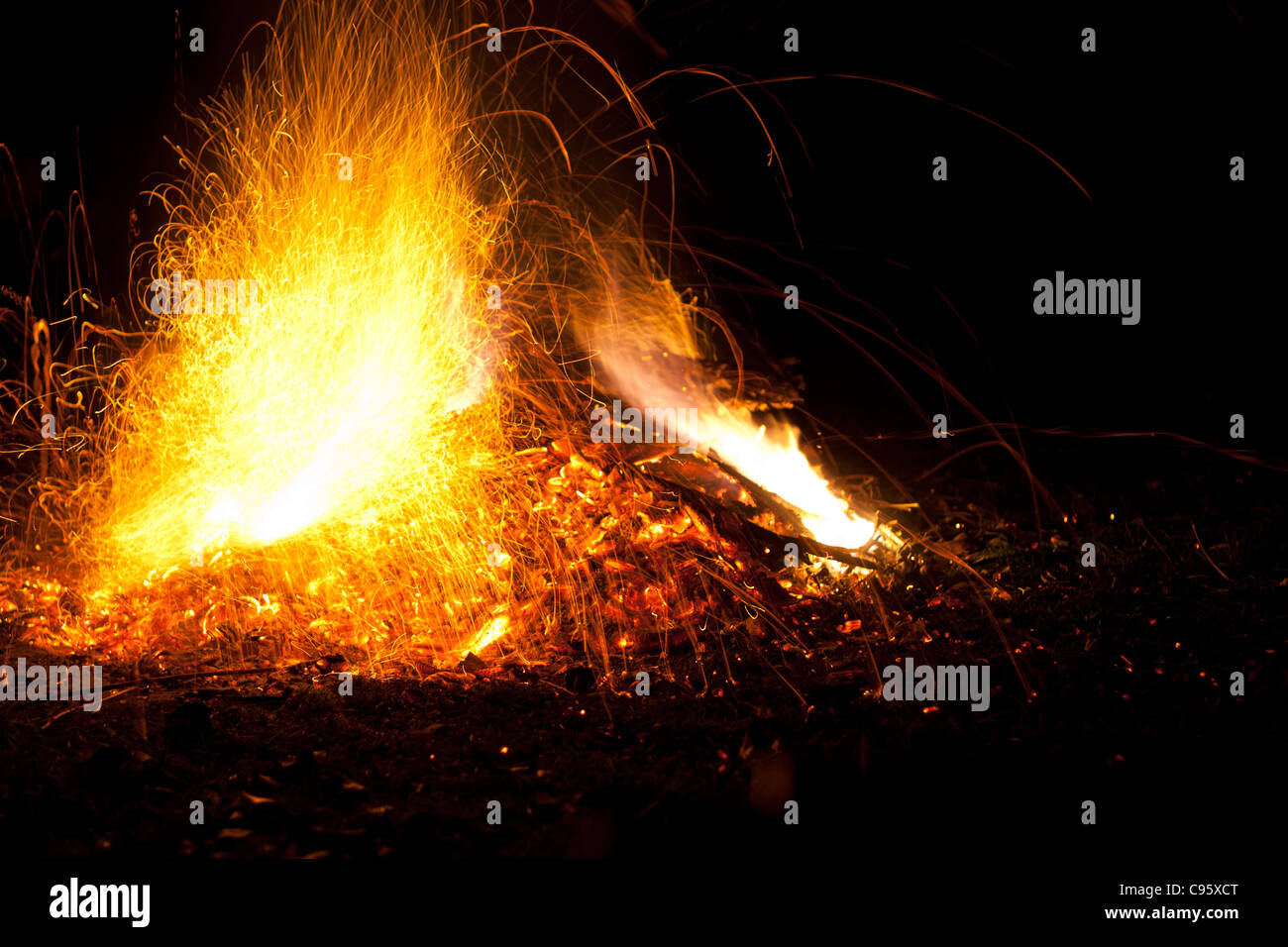 Feuer mit Flammen und Funken. Intensiv orange, gelben Schein der Lagerfeuer vor dem Hintergrund der schwarzen Nacht. Stockfoto