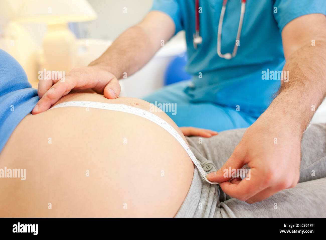 Geburtshilfliche Untersuchung. Messung einer schwangeren Bauch bei einer Hausgeburt Hebamme. Stockfoto