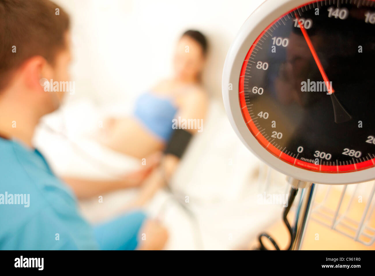 Geburtshilfliche Untersuchung. Eine schwangere Frau Blutdruckmessung bei einer Hausgeburt Hebamme. Stockfoto