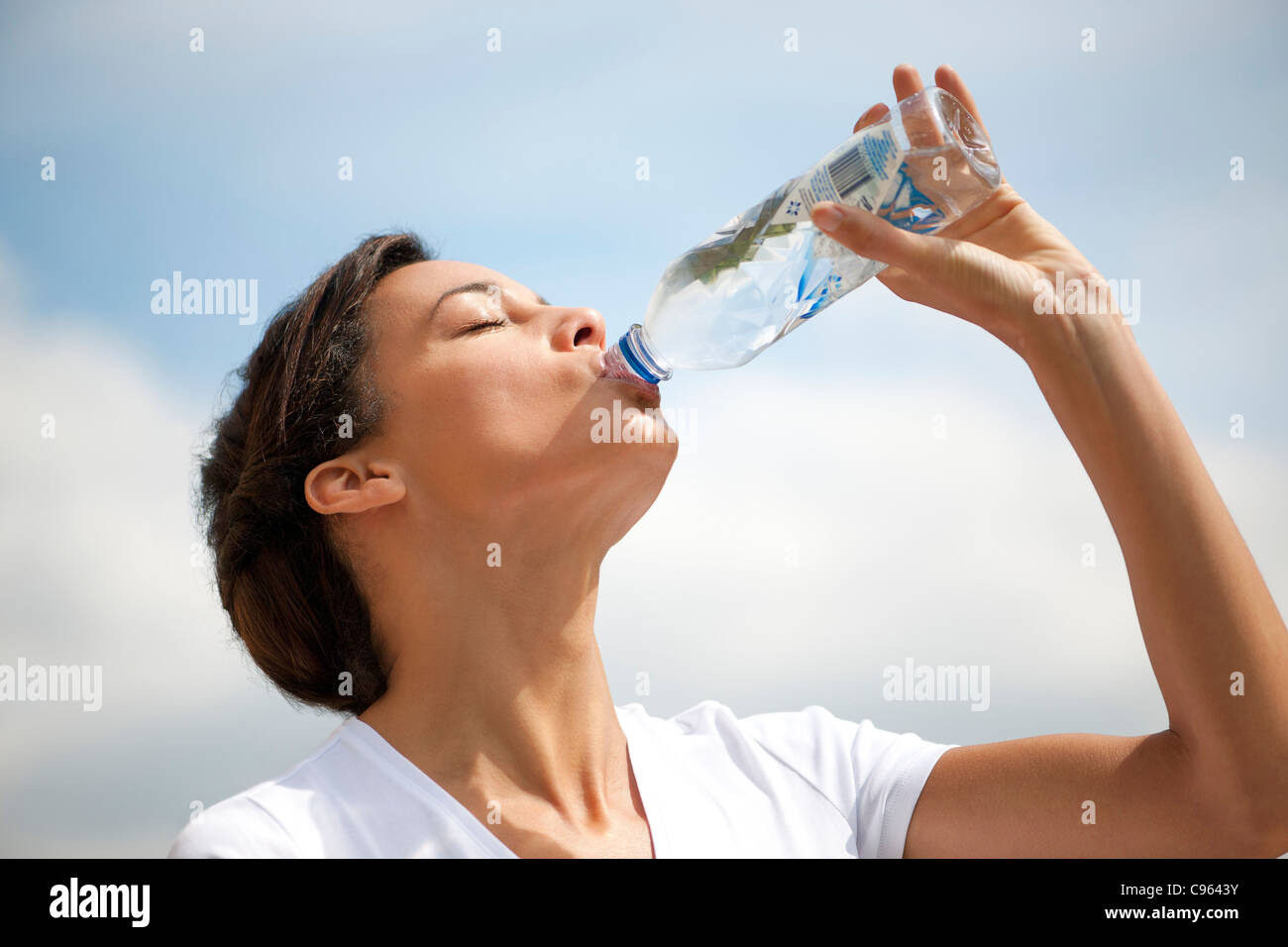 Frau trinkt Mineralwasser. Stockfoto