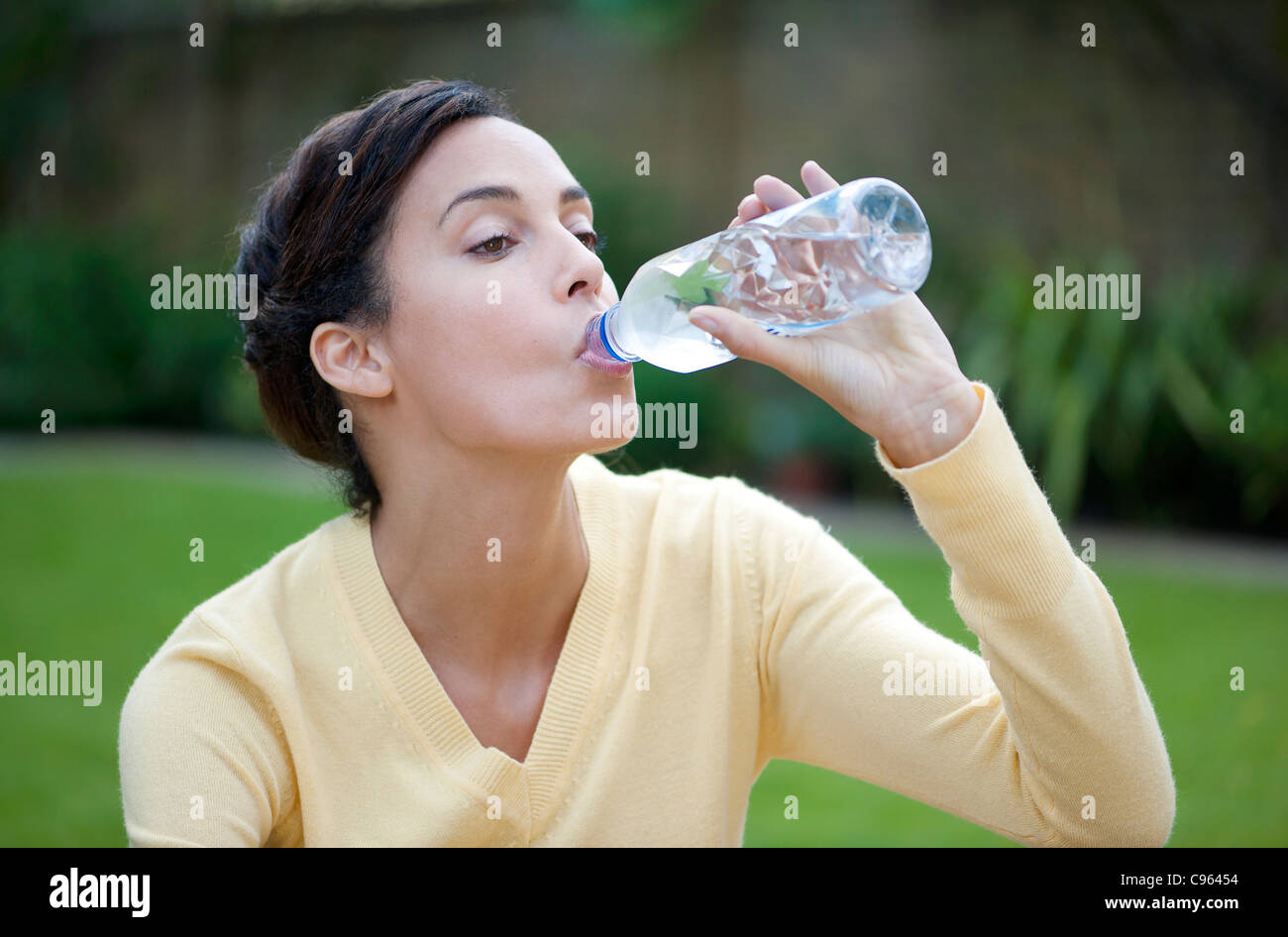 Frau trinkt Mineralwasser. Stockfoto
