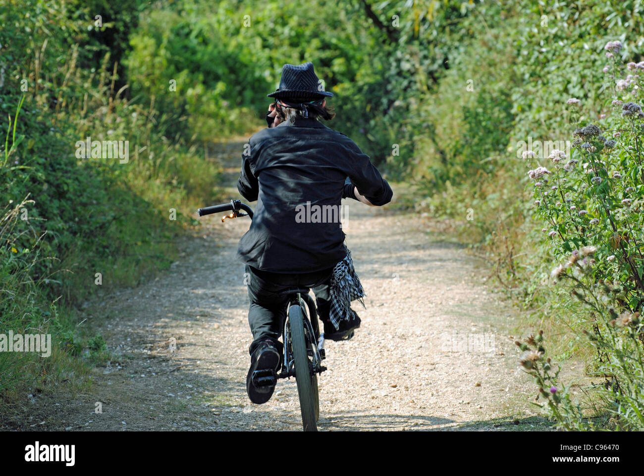 Mann in schwarz auf einem Fahrrad Stockfoto