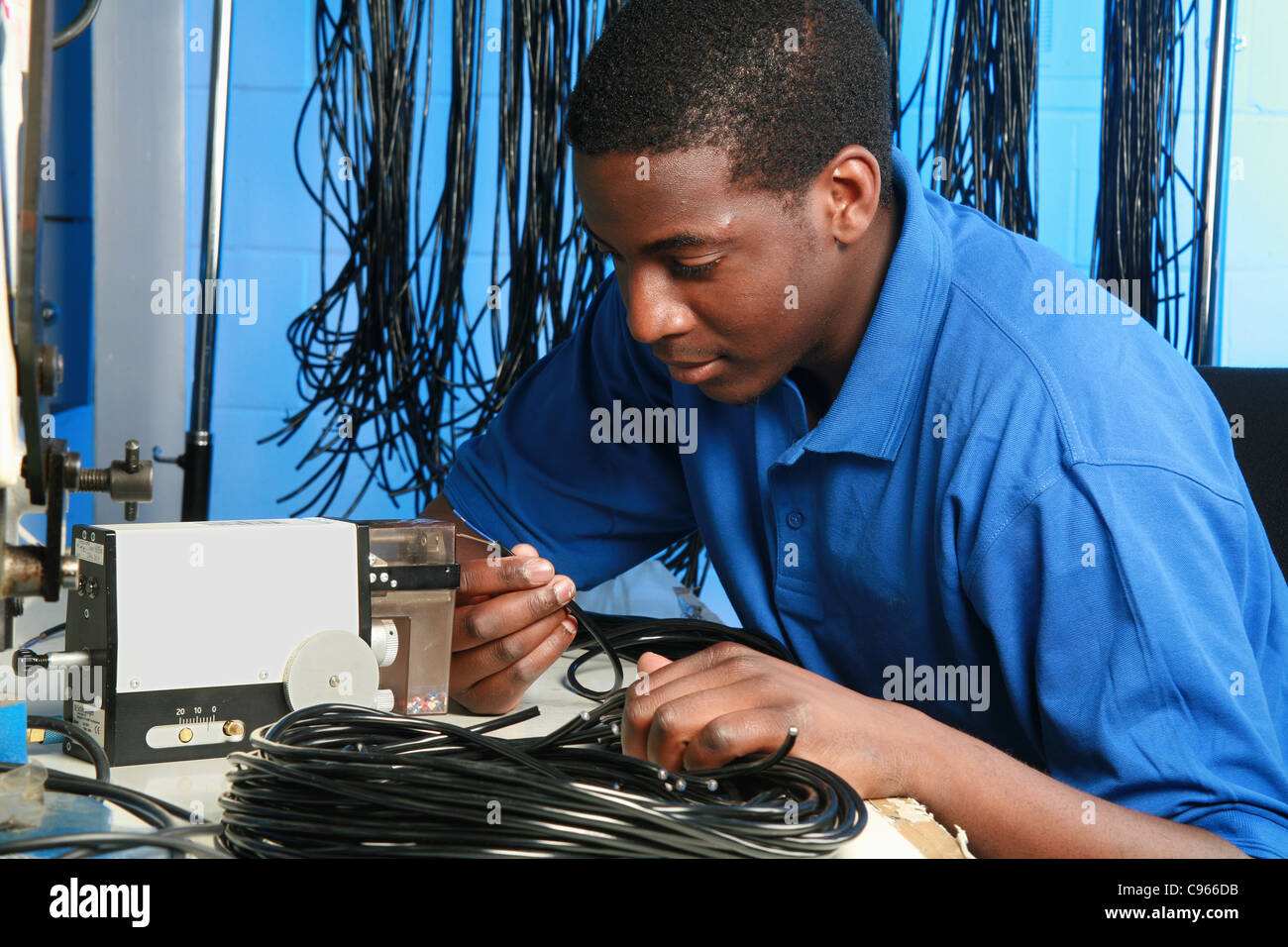 junge schwarze männliche Arbeiter in einer Fabrik für elektronische Bauteile Stockfoto