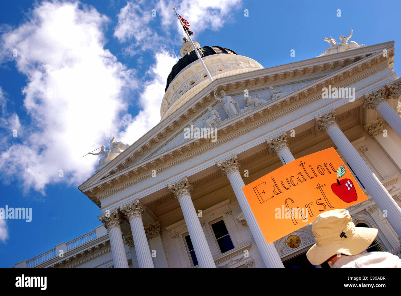 Verfechter der Bildung hält ein Schild mit der Aufschrift "Education First" an der California State Capitol in Sacramento, Kalifornien Stockfoto