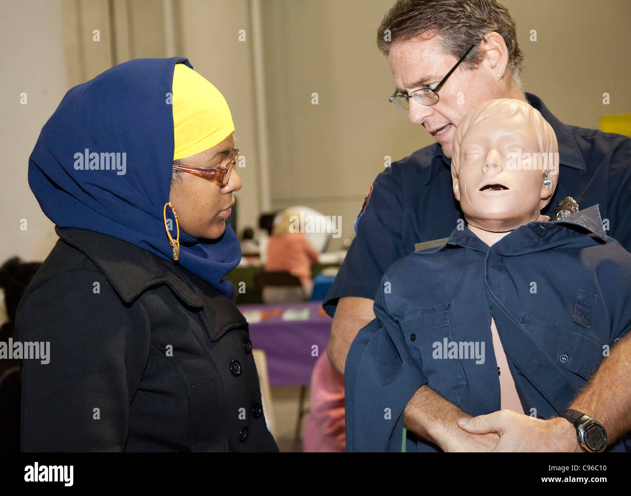 Detroit, Michigan - ein Rettungssanitäter lehrt das Heimlich-Manöver für einer Person, die Teilnahme an einer Gemeinschaft Gesundheitsmesse. Stockfoto