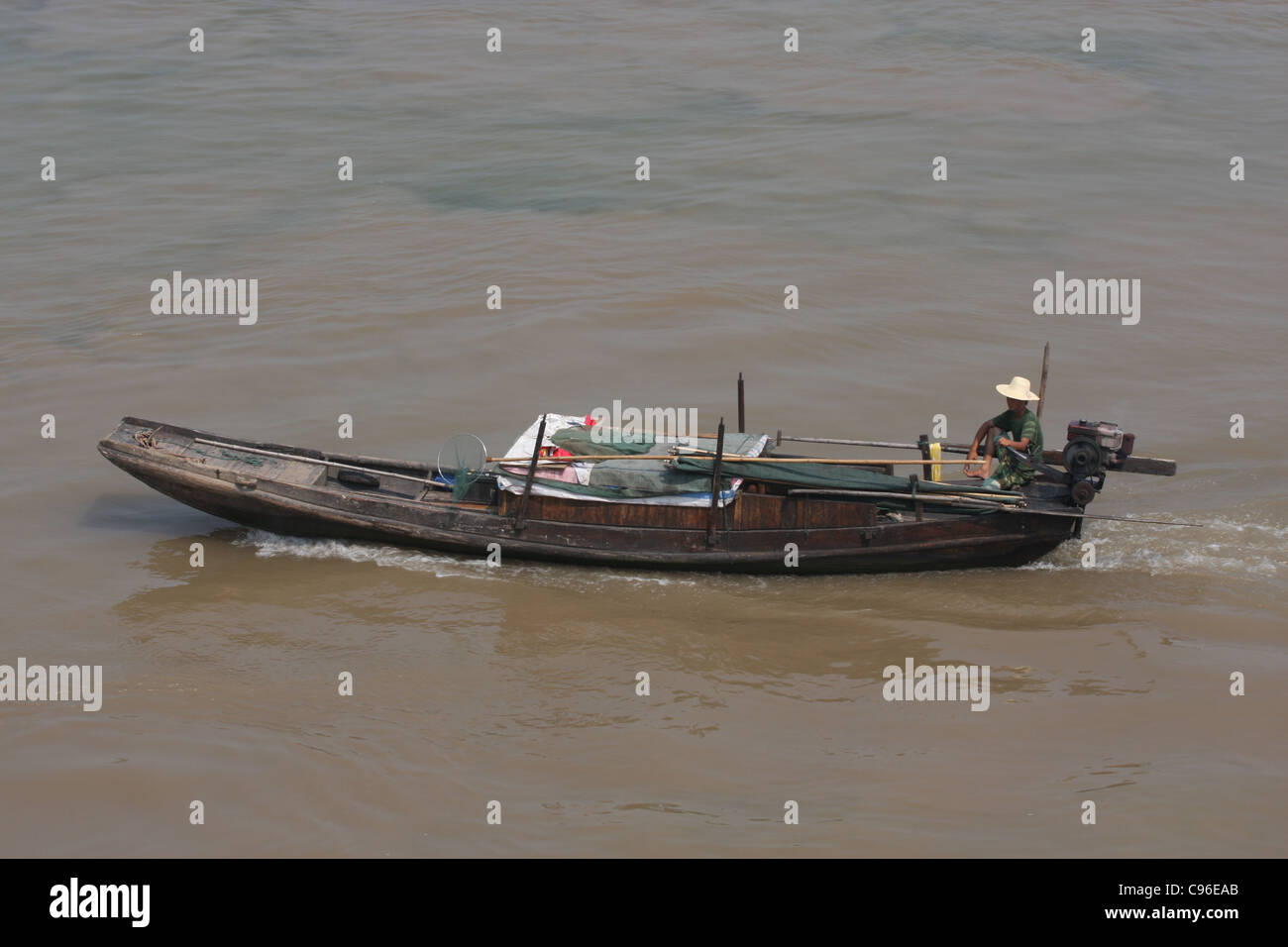Mann in einen Strohhut auf der Deichsel von einem Sampan am Jangtse-Fluss in Chizhou, China Stockfoto