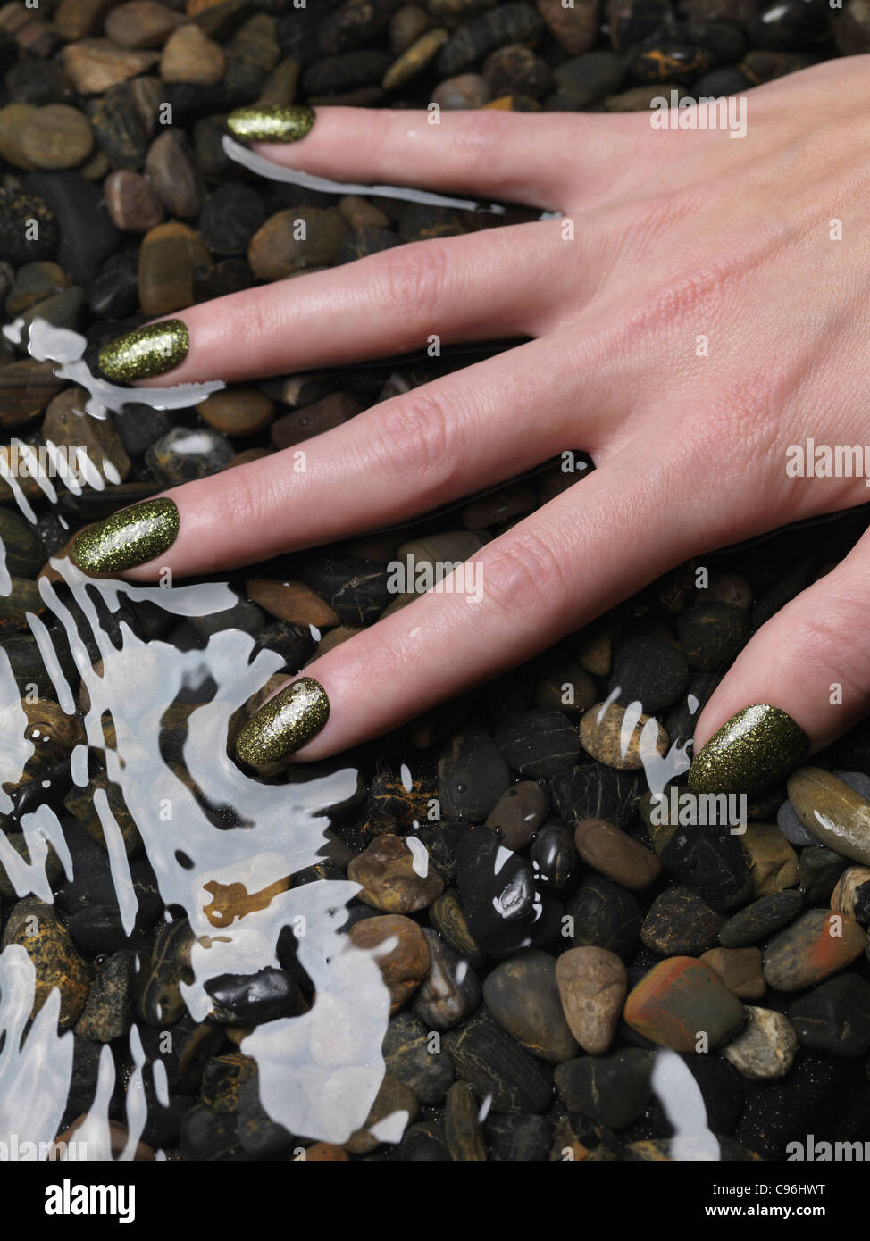 Lizenz erhältlich unter MaximImages.com Nahaufnahme der Frauenhand mit grünem, feinem nagellack in Wasser Stockfoto