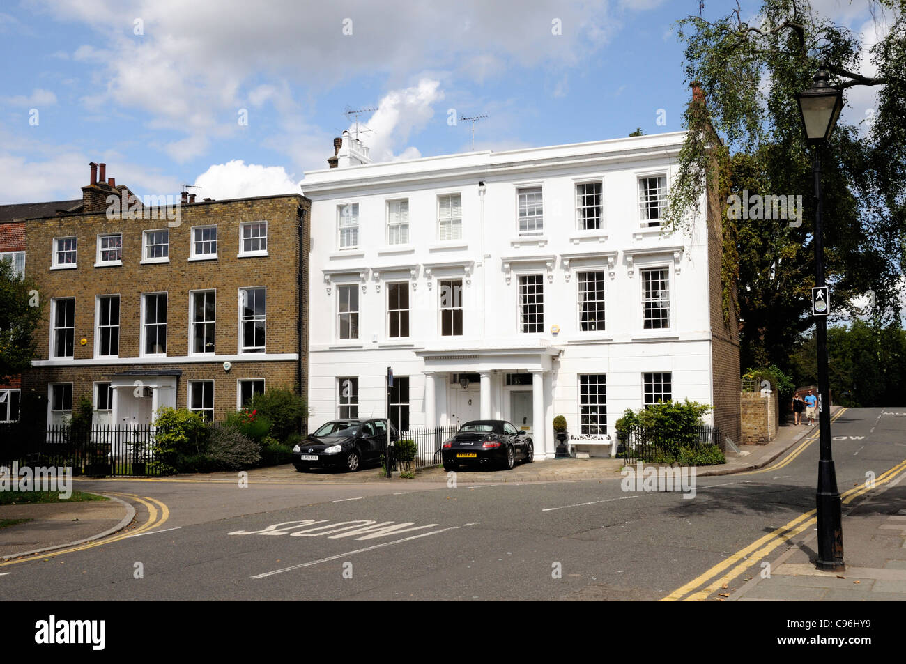 Weiß lackiertes Ende der Reihenhäuser neben Ziegel Häuser, The Green, Richmond upon Thames, Surrey England UK Stockfoto