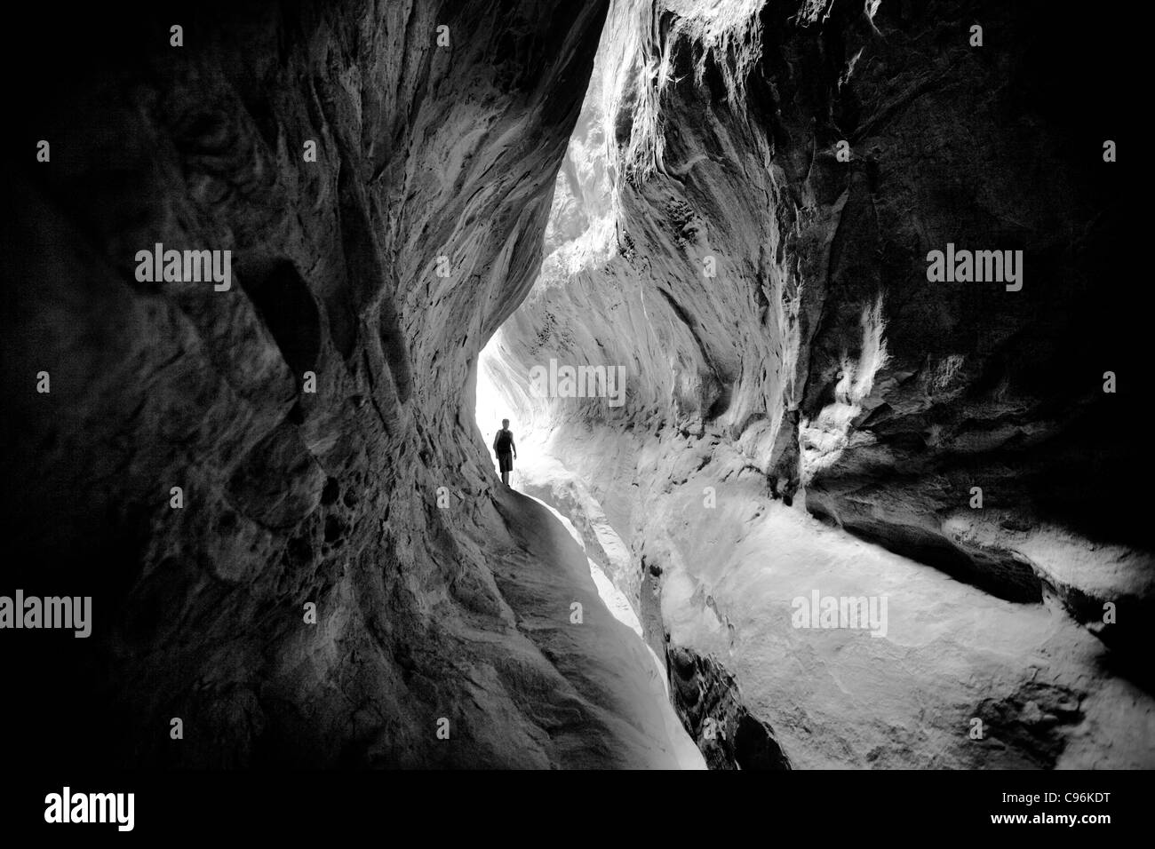 Einsamer Explorer im Rock-Tunnel - B&W Stockfoto