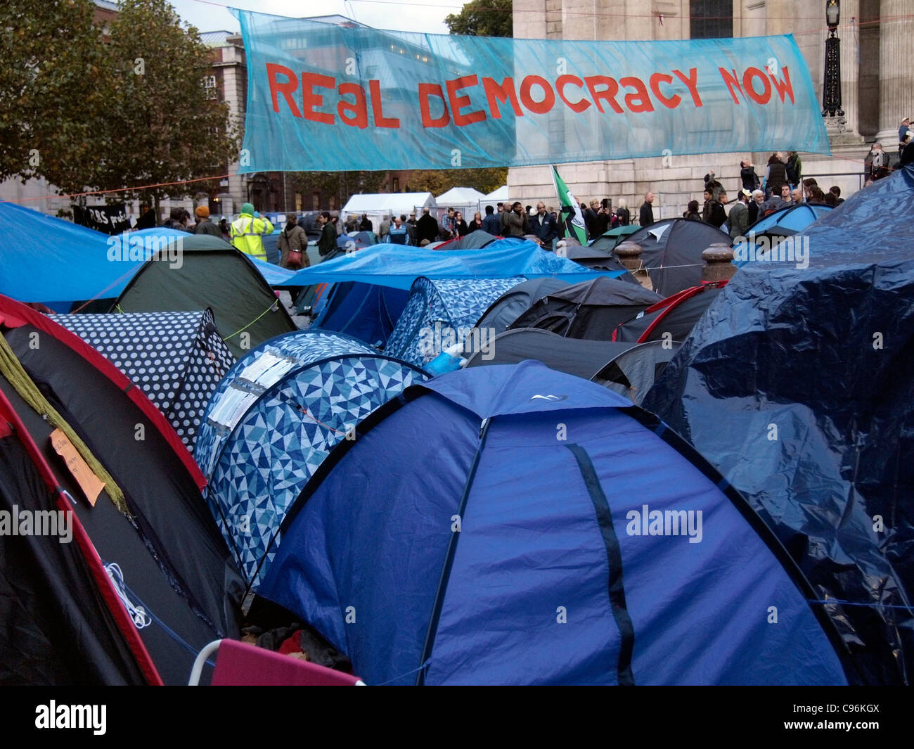 Demonstranten und Zelten außerhalb von St. Pauls Cathedral London antikapitalistische Demonstration 2011 mit Banner, die Förderung der Demokratie Stockfoto