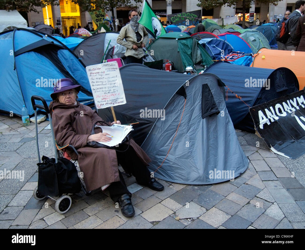 Demonstranten und Zelten außerhalb von St. Pauls Cathedral London mit weibliche Person und Plakat antikapitalistische Demonstration 2011 Stockfoto