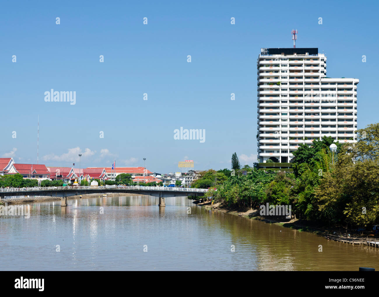 Ansicht des Flusses Ping in Chiang Mai in Thailand mit einer Brücke & Gebäude im Abstand Stockfoto