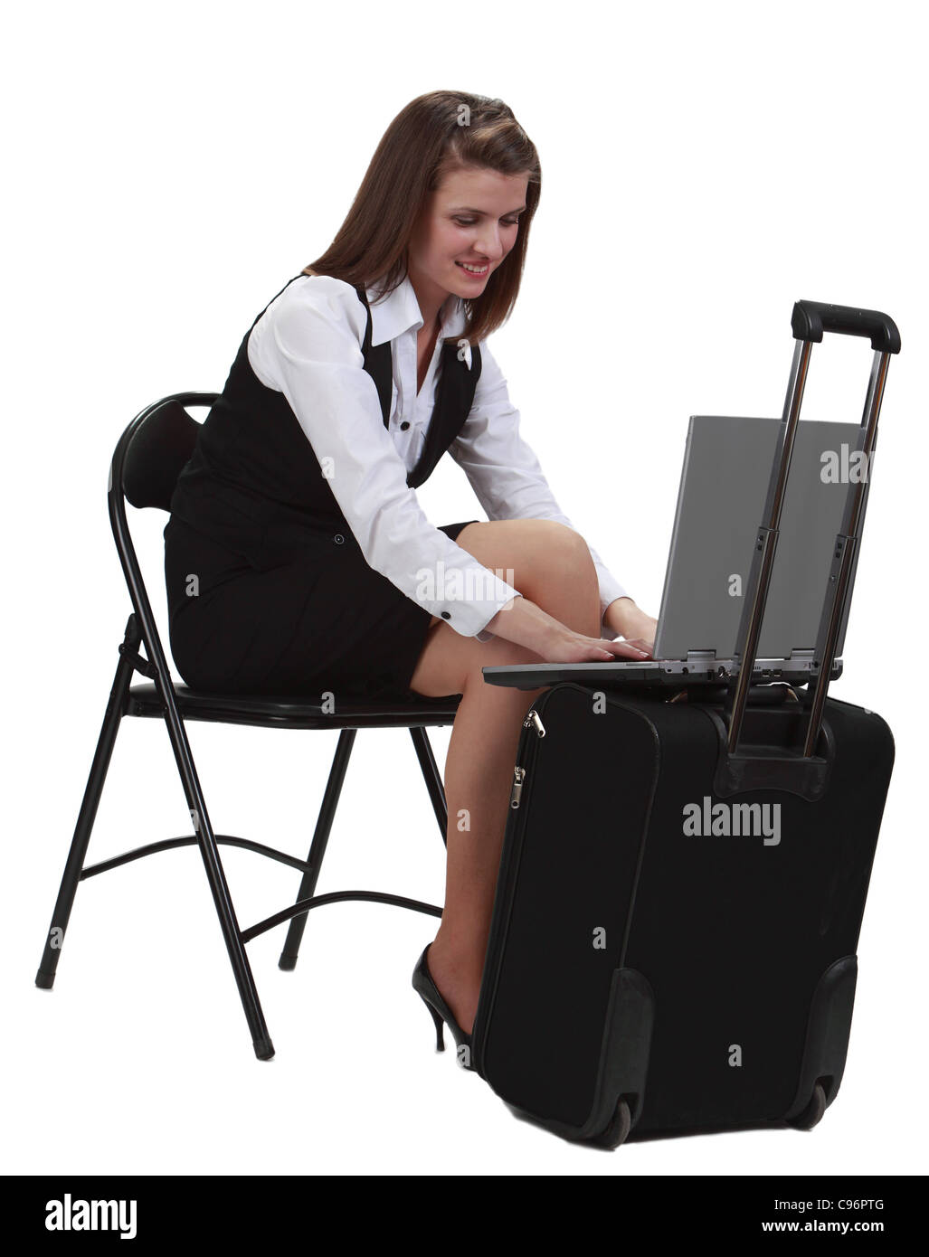 Junge Frau Reisenden in Eile auf ihr Latop auf einen Koffer-vor einem weißen Hintergrund isoliert arbeiten. Stockfoto