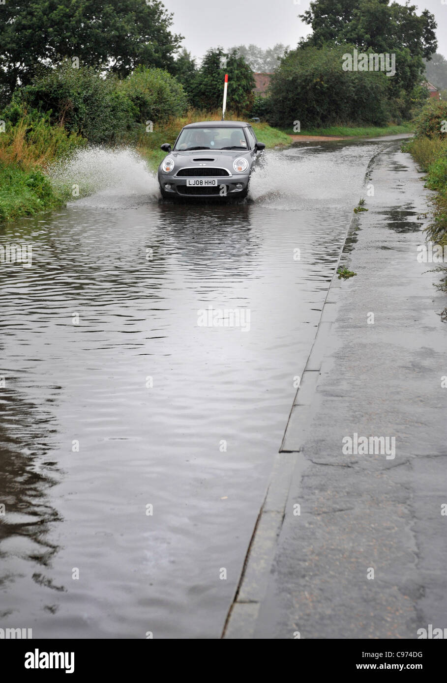 Auto fährt durch überfluteten Landstraße Stockfoto