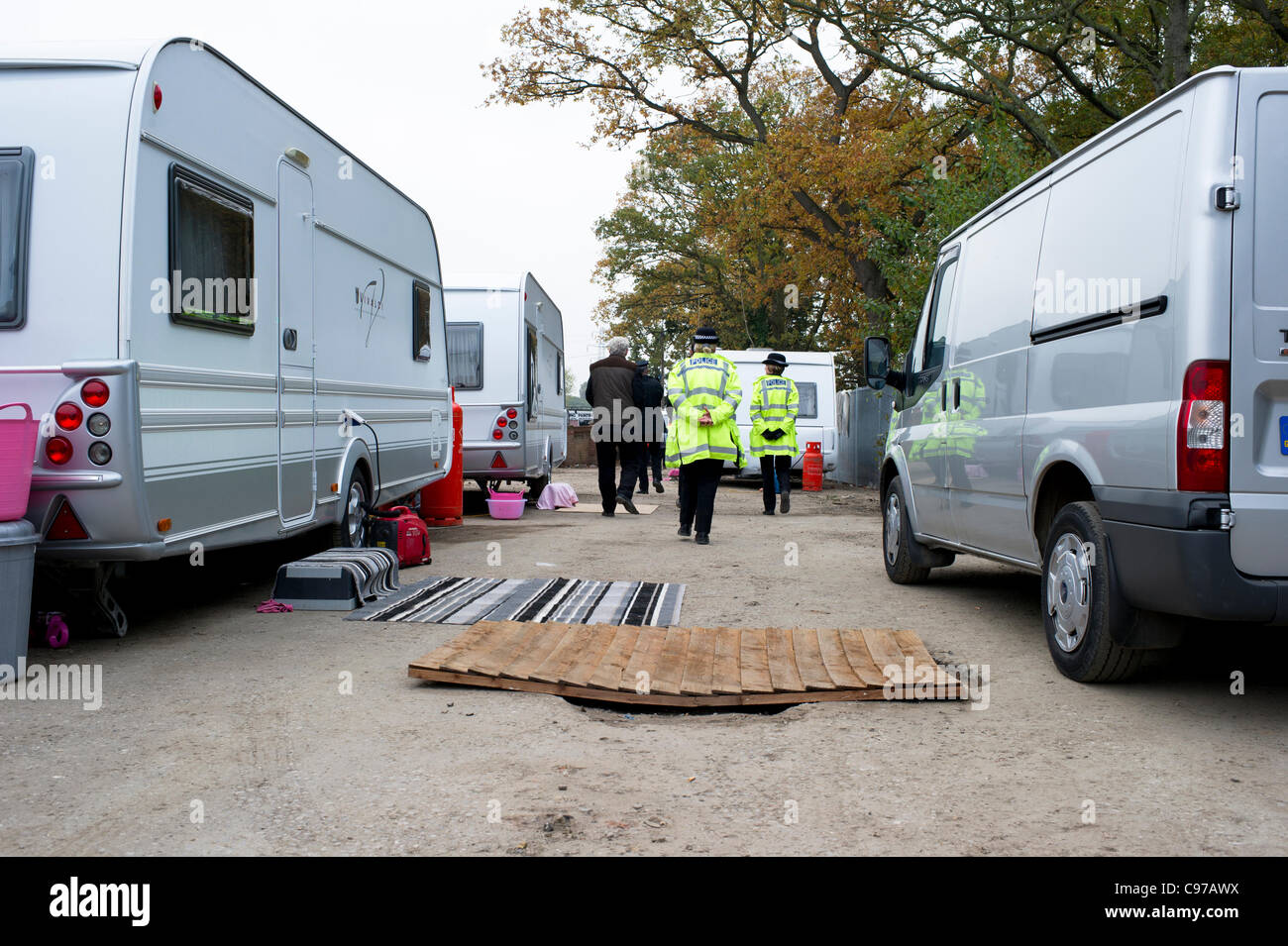 16. November 2011. Dale Farm Essex, England. Polizisten Fuß zwischen Wohnwagen gehören für Reisende, die sich wieder auf die illegale Seite des Standortes Reisende bei Dale Farm, Basildon verschoben haben. Basildon Rat Vollzugsbeamten besuchte den Ort um Durchsetzung Mitteilungen an Reisende verteilen. Stockfoto