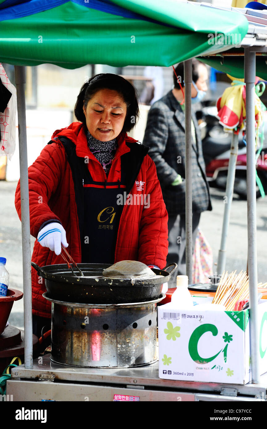 Eine Frau, die Kochen Fisch am Jagalchi-Fischmarkt, Busan, Südkorea. Stockfoto