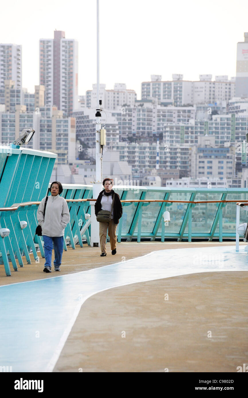 Asiatischen Passagiere zu Fuß auf dem Deck einer Royal Caribbean Kreuzfahrt Schiff in Busan, Südkorea. Stockfoto