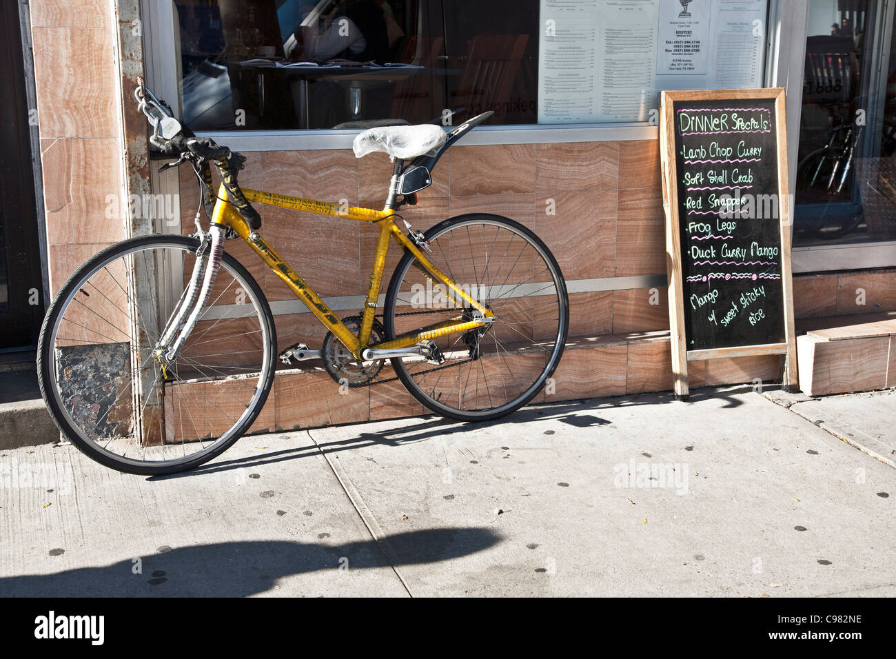 Vorhängeschloss Lieferung Fahrrad & Tafel Menü außerhalb Ninth Avenue Restaurant in Hells Kitchen Nachbarschaft New York City Stockfoto