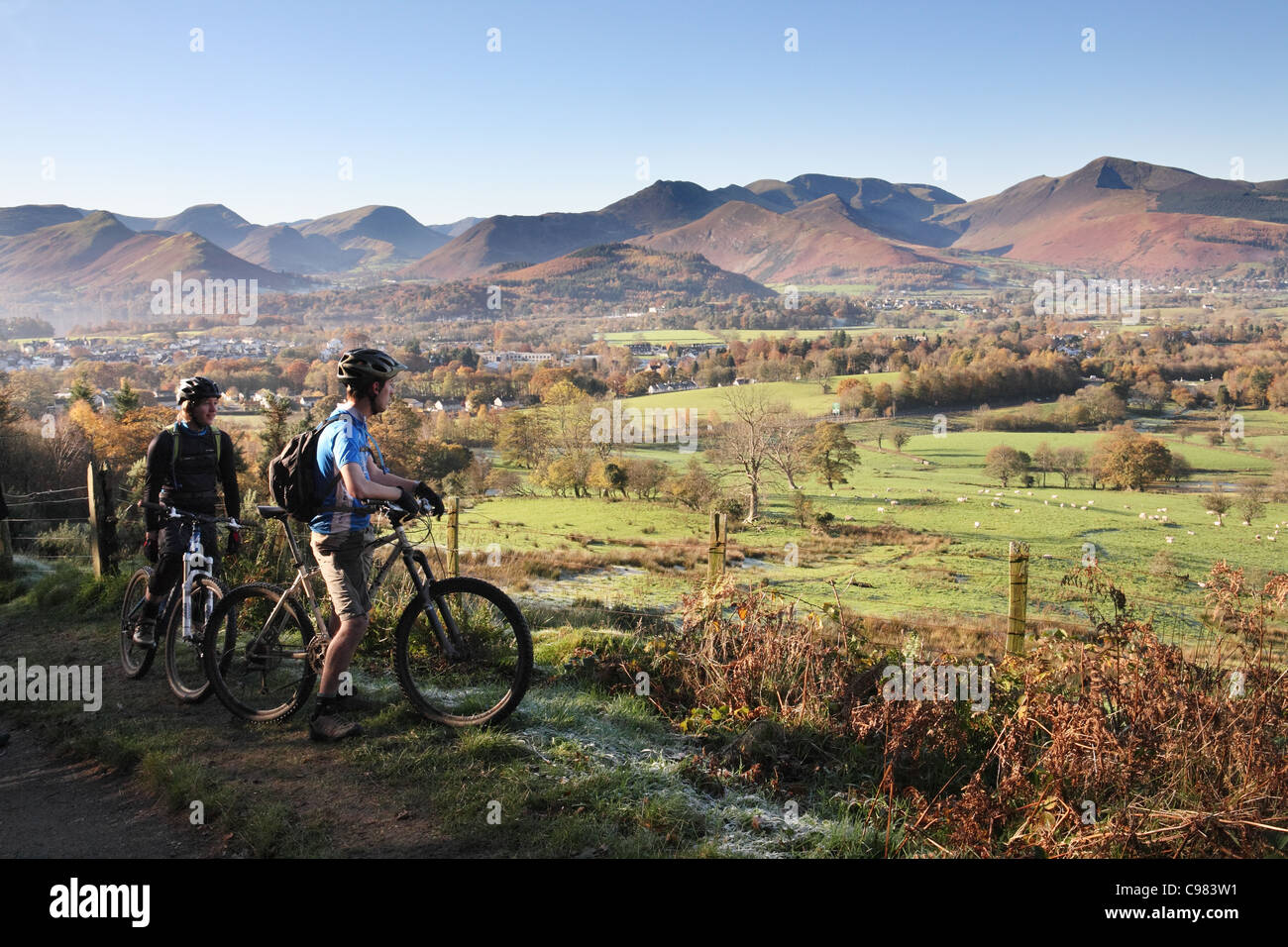 Zwei Mountainbiker genießen Sie den Blick in Richtung der Derwent Fells von der Basis des Latrigg, englischen Lake District, Cumbria, UK Stockfoto