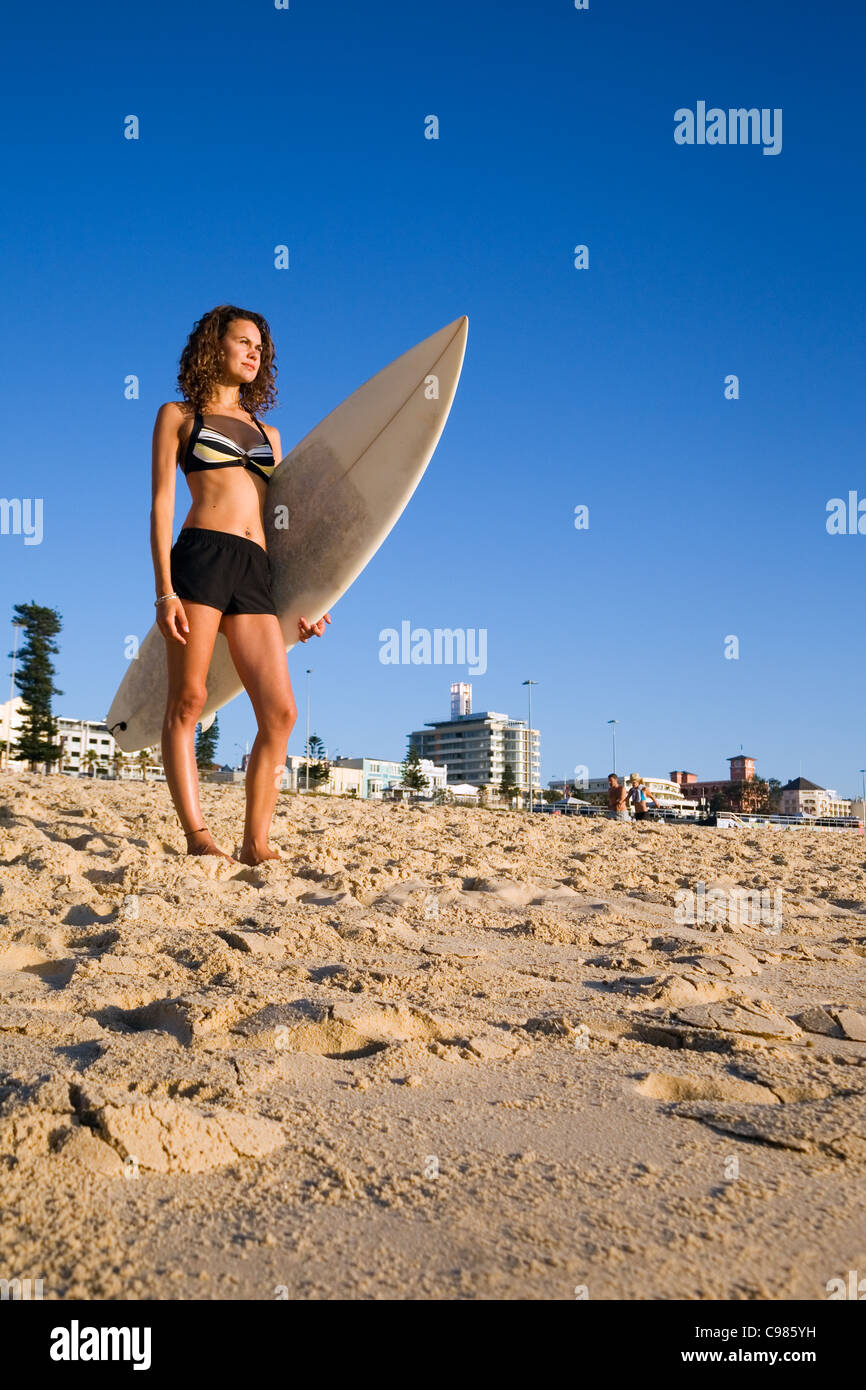 Surferin stehend mit Surfbrett am Bondi Beach.  Sydney, New South Wales, Australien Stockfoto