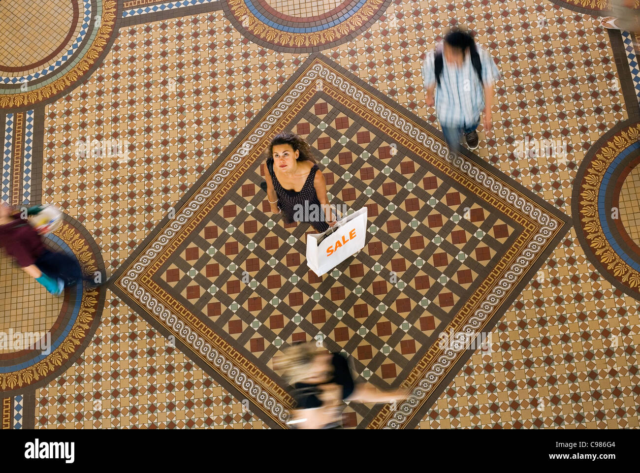 Eine Frau, die Einkaufstasche stehen in der Mall, als Käufer vorbei.  Sydney, New South Wales, Australien Stockfoto