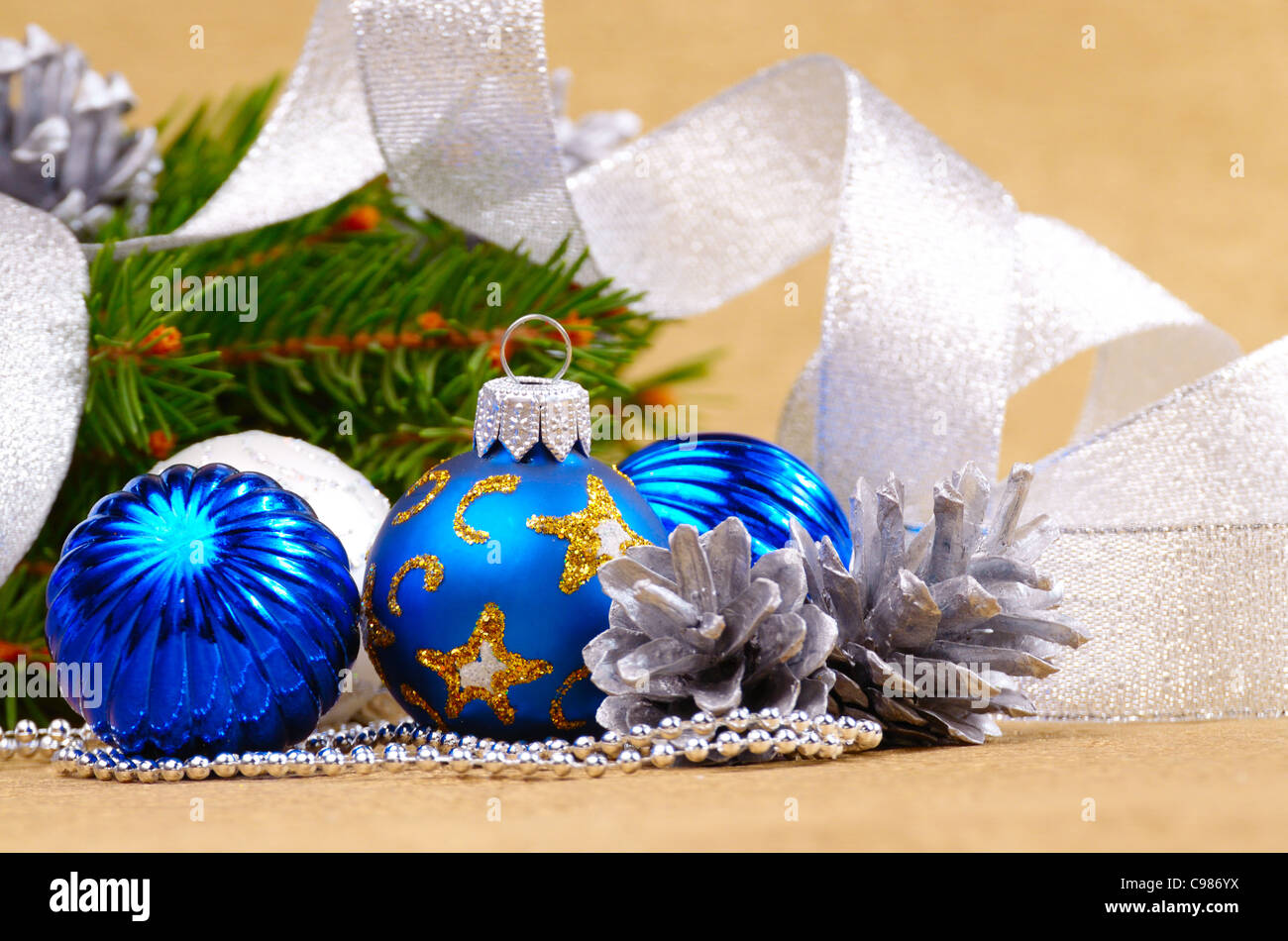 Blaue und weiße Weihnachtskugeln auf goldenem Hintergrund Stockfoto