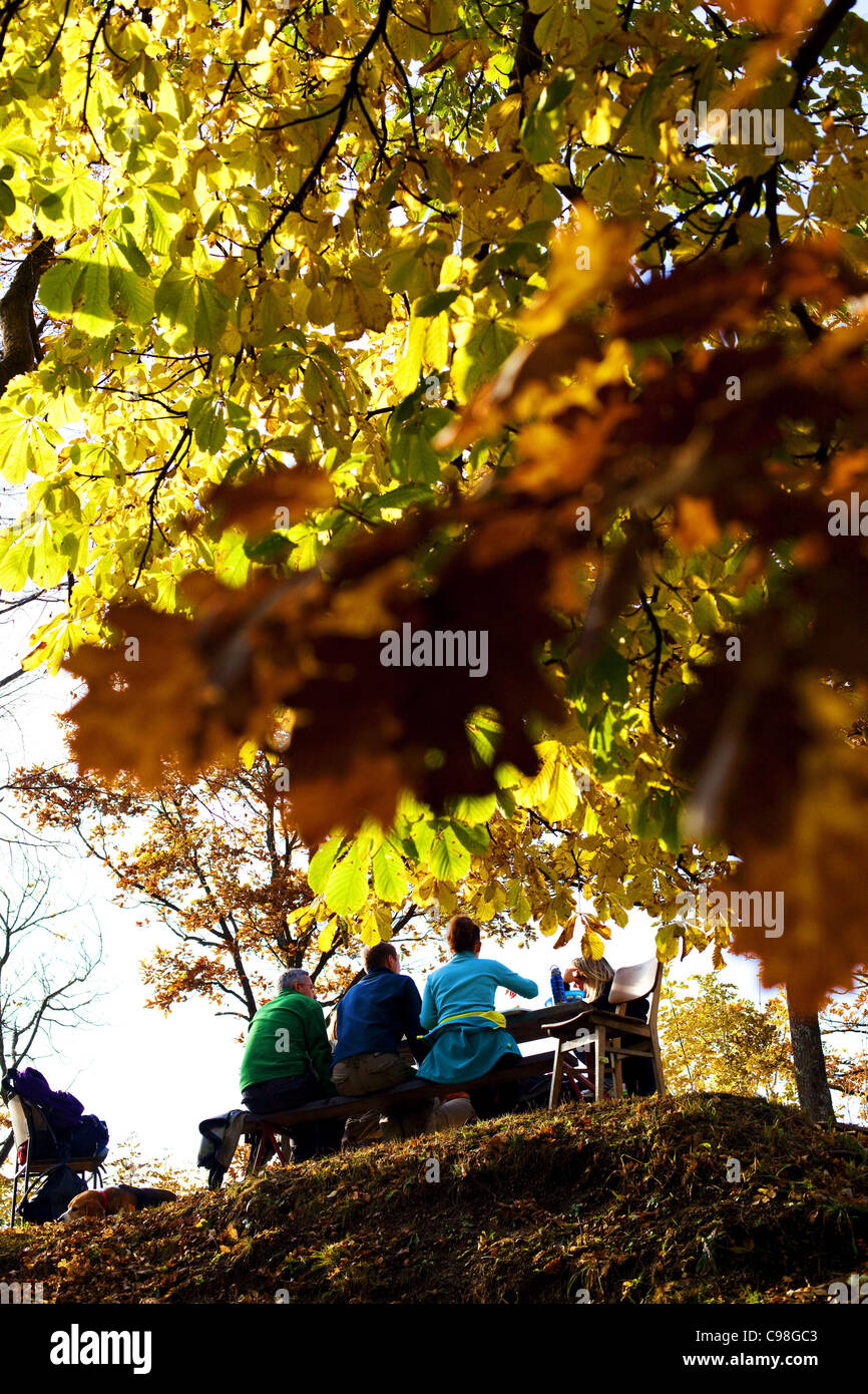 Menschen sitzen auf Bank in der Natur im Herbst. Stockfoto