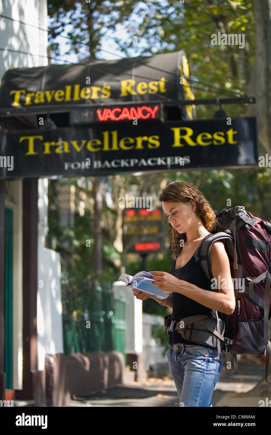 Eine Backpacker liest ihr Ratgeber außerhalb einer Jugendherberge. Kings Cross, Sydney, New South Wales, Australien Stockfoto