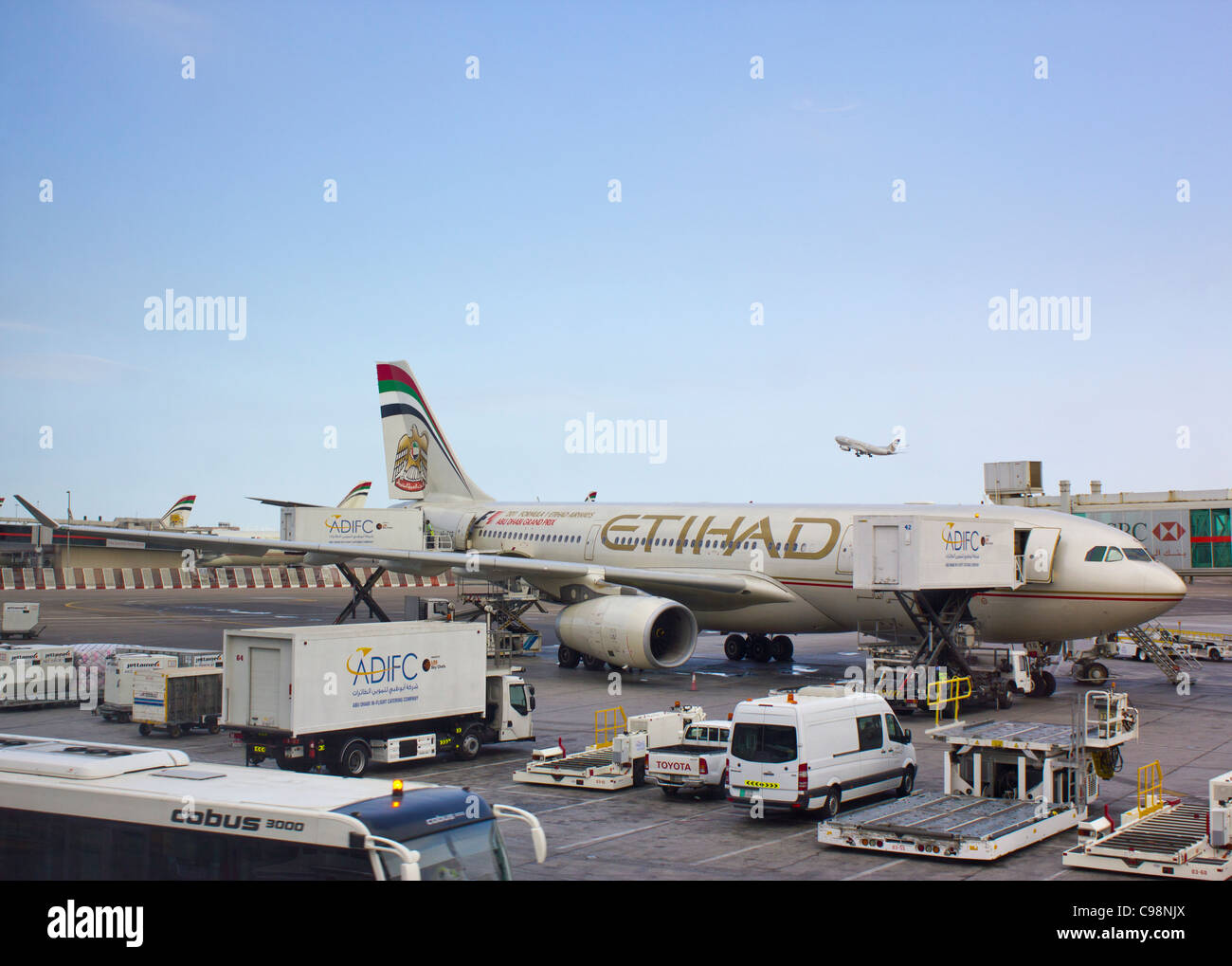 Airbus A330-200 Etihad-Airways-Maschine am Terminal 1, Flughafen Abu Dhabi, Vereinigte Arabische Emirate; ein weiteres Etihad-Flugzeug im Hintergrund Stockfoto