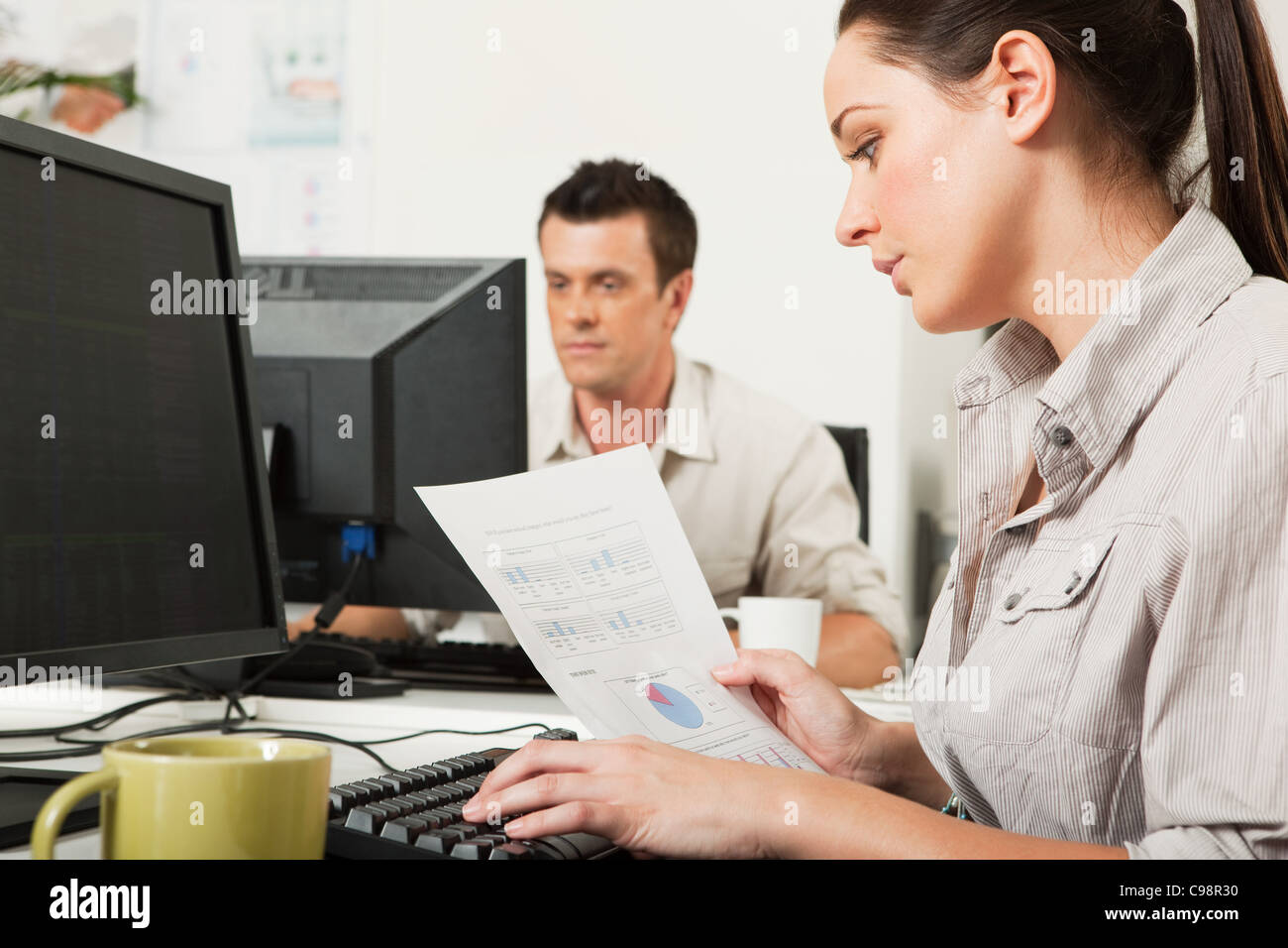 Büroangestellte sucht Grafiken auf dem Stück Papier Stockfoto