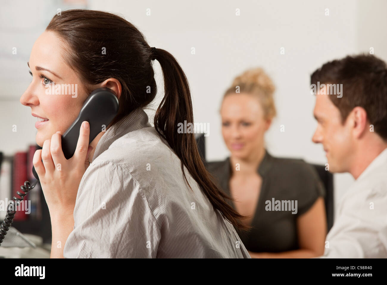 Weibliche Angestellte mit Telefonbüro Stockfoto
