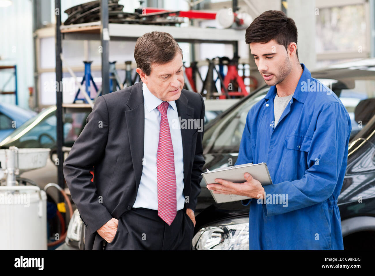 Geschäftsmann mit Auto-Mechaniker-Werkstatt Stockfoto