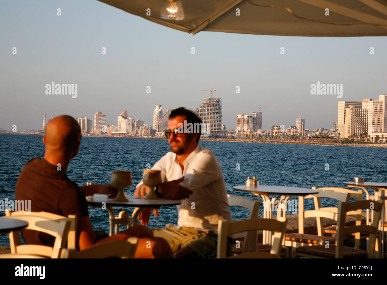 Menschen sitzen im Casita Bar & Restaurant in der Altstadt von Jaffa mit Blick auf das Meer und Tel Aviv, Israel. Stockfoto