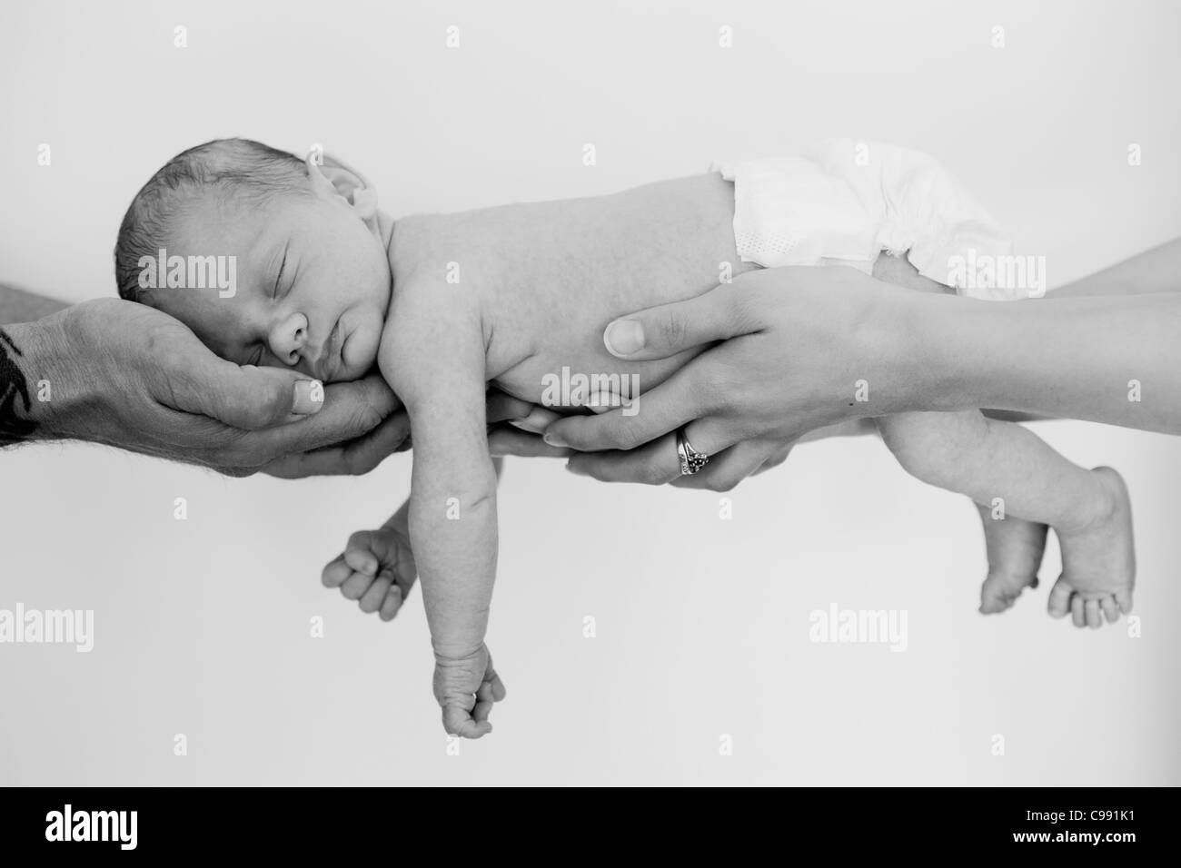 Mutterschaft Fotografie ein befreundeter kleiner Junge in seiner Mutter und Väter Arme. Stockfoto