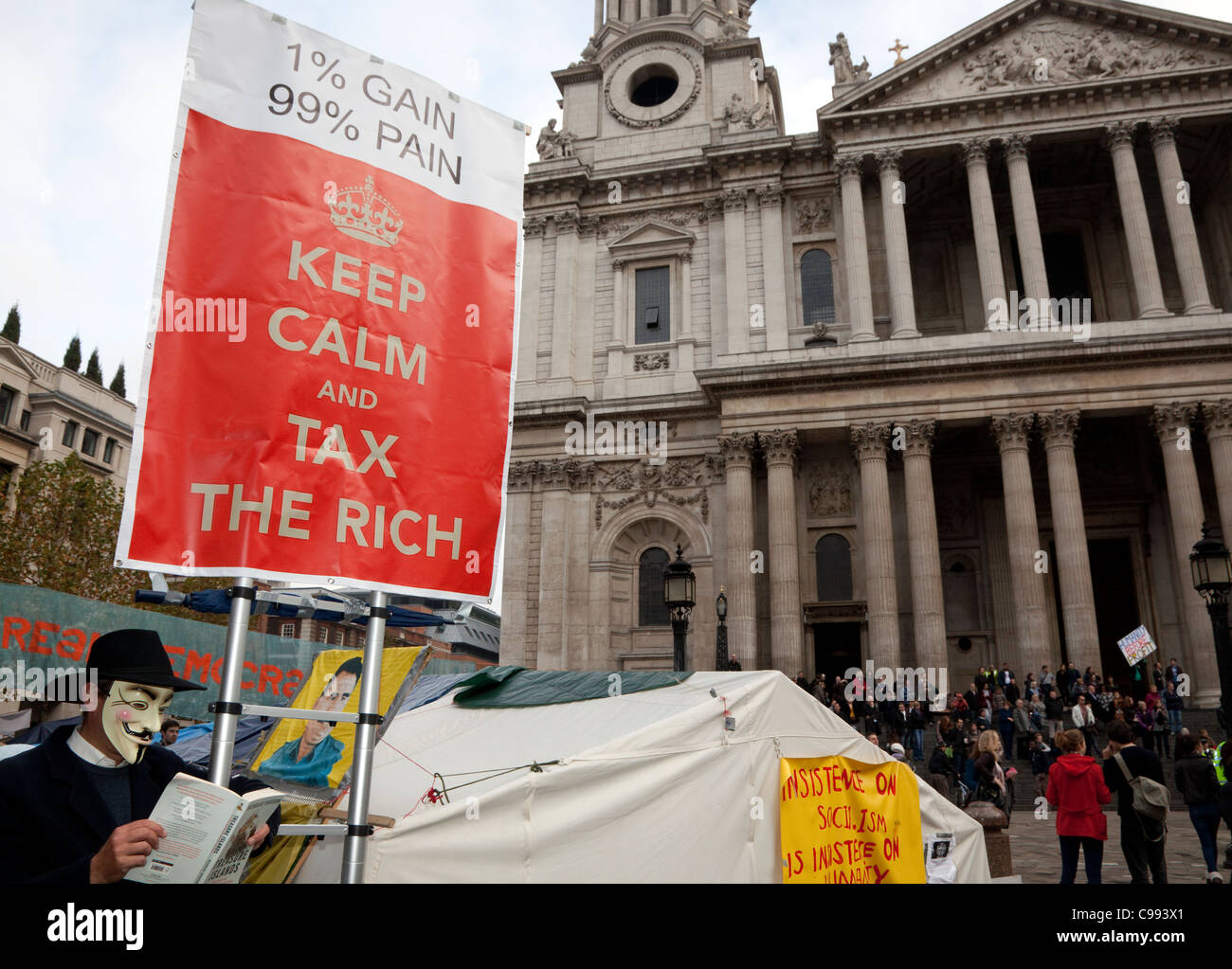 Aktivist mit Buch über Steueroasen in besetzen Camp, St. Pauls Cathedral, London Stockfoto