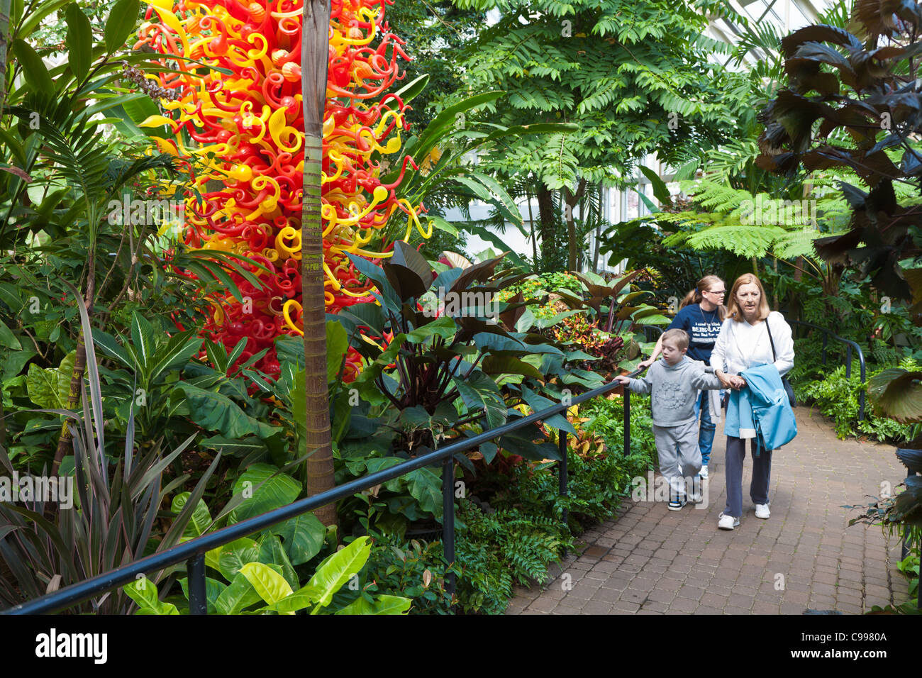 Besucher des Parks Fuß vorbei an Dale Chihuly Glas Kunstwerke am Franklin Park Conservatory in Columbus, Ohio. Stockfoto