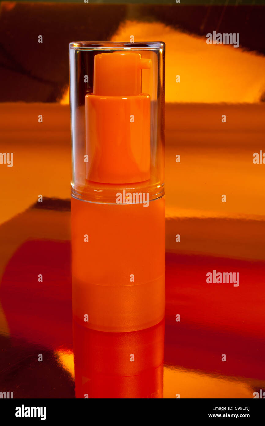 Orange Flasche auf reflektierende Oberfläche Stockfoto