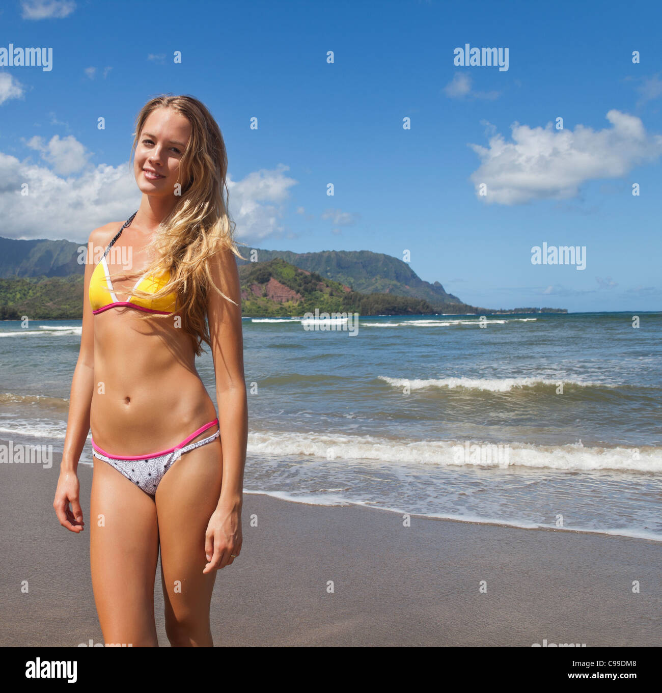 Junge Frau im Hanalei Beach auf Kauai mit Mt. Makana genannt Bali Hai, in der Ferne Stockfoto