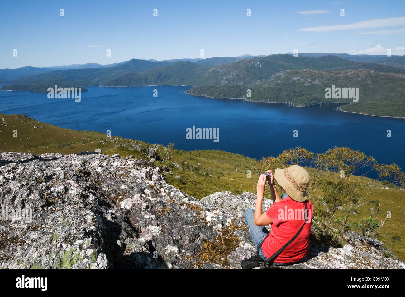 Ein Wanderer Fotografien Lake Mackintosh von oben auf Mount Farrell, im westlichen Hochland Tasmaniens. Tullah, Tasmanien, Australien Stockfoto