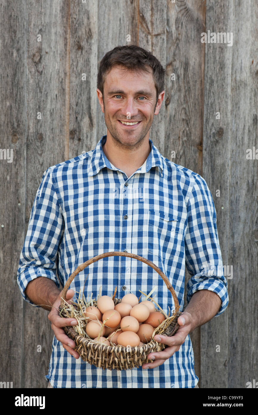 Deutschland, Bayern, Altenthann, Mann hält Korb mit Eiern, Lächeln, Porträt Stockfoto