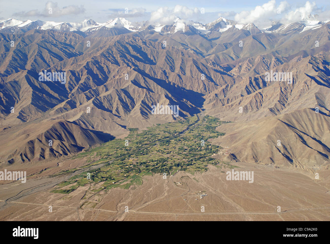 Arial Ansicht der Schnee verkleidet Himalaya Gebirge - Heimat der weltweit höchsten Gipfeln, grünen Feldern, Wohngebäude finden Stockfoto