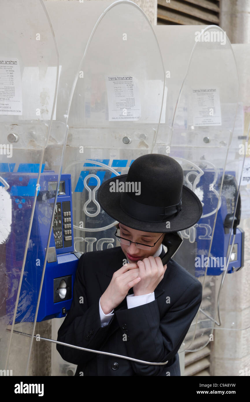 Porträt des orthodoxen jüdischen Jugendlicher an einem öffentlichen Telefon sprechen. Mea Shearim. Jerusalem. Israel Stockfoto