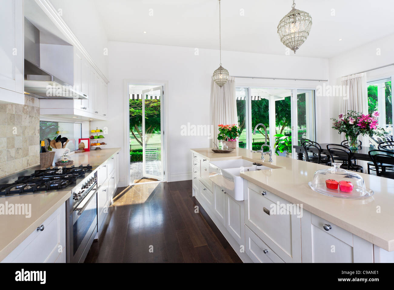 Stilvolle offene Küche mit Geräten aus rostfreiem Stahl und Essbereich mit Blick auf Pool und Golfplatz Stockfoto